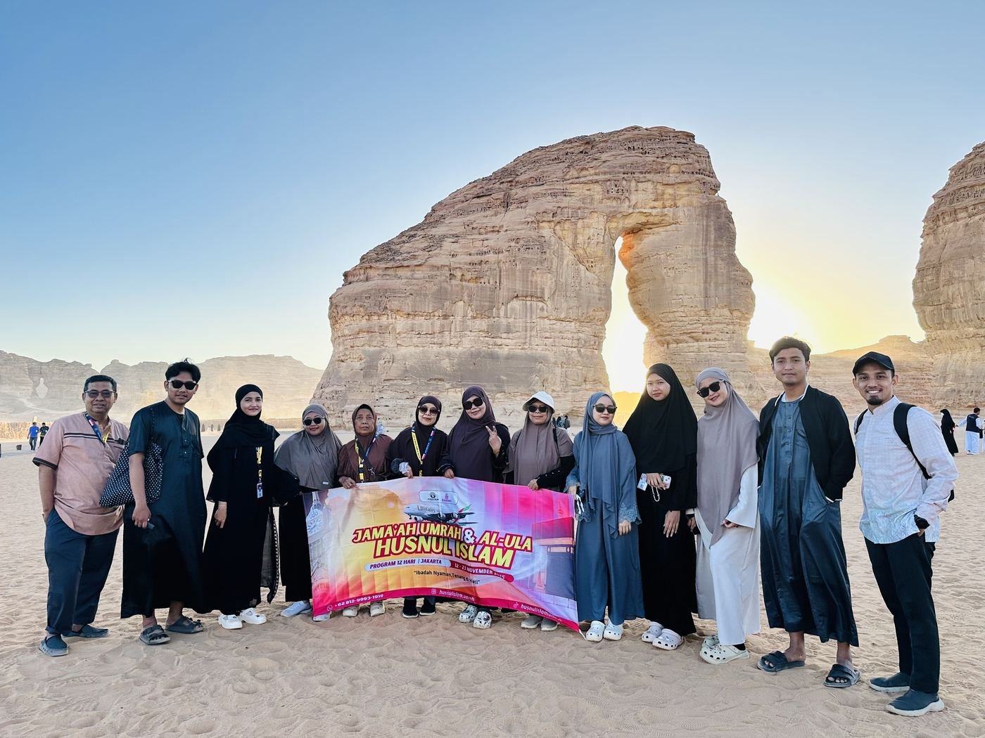 Jamaah Husnul Islam membentangkan spanduk program Umrah dan Al-Ula di depan Elephant Rock, Al-Ula